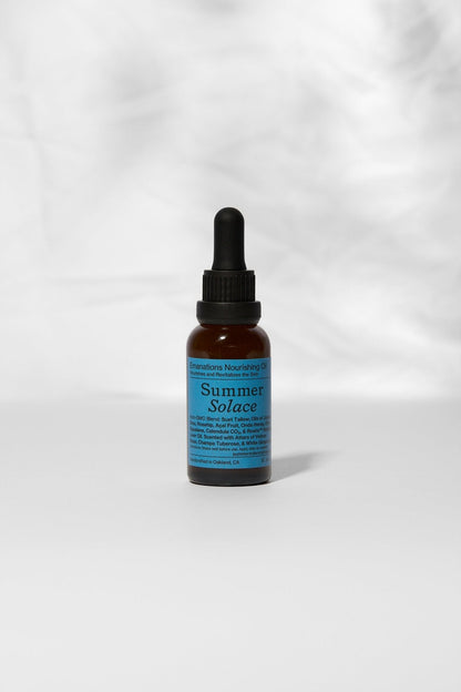 An amber dropper bottle labeled "Summer Solace Tallow" stands upright on a light surface. Its blue label reads "Emanations Profound Face Oil – Deeply Nourishing | Champa, Tuberose & White Ginger Lily," a nourishing face and hair oil.