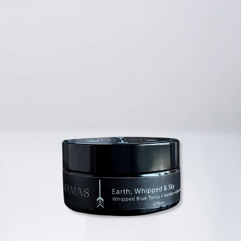 A black jar of Wild Mamas Earth, Whipped & Sky 3.16oz rests on a light gray surface with a matching background, featuring luxurious whipped tallow balm made from regenerative bison tallow skincare.