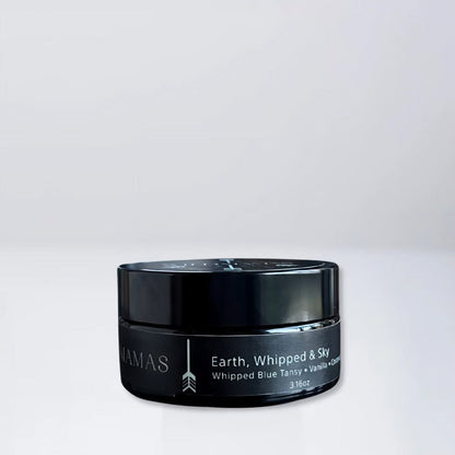 A black jar of Wild Mamas Earth, Whipped & Sky 3.16oz rests on a light gray surface with a matching background, featuring luxurious whipped tallow balm made from regenerative bison tallow skincare.