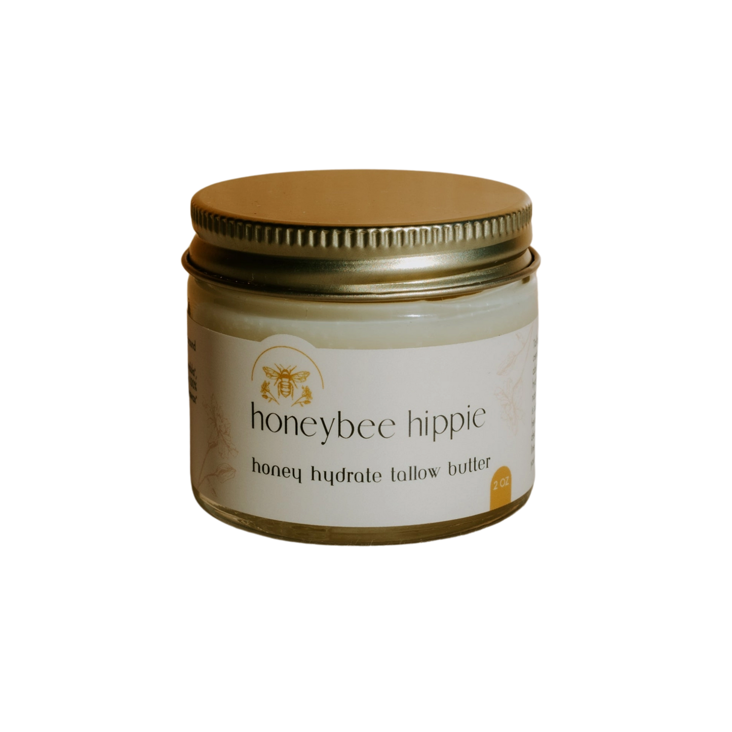 The small jar with a gold lid features "honey hydrate tallow butter" from Honeybee Hippie. With a bee illustration on its label, set against black, it exudes organic charm and promises natural nourishment.
