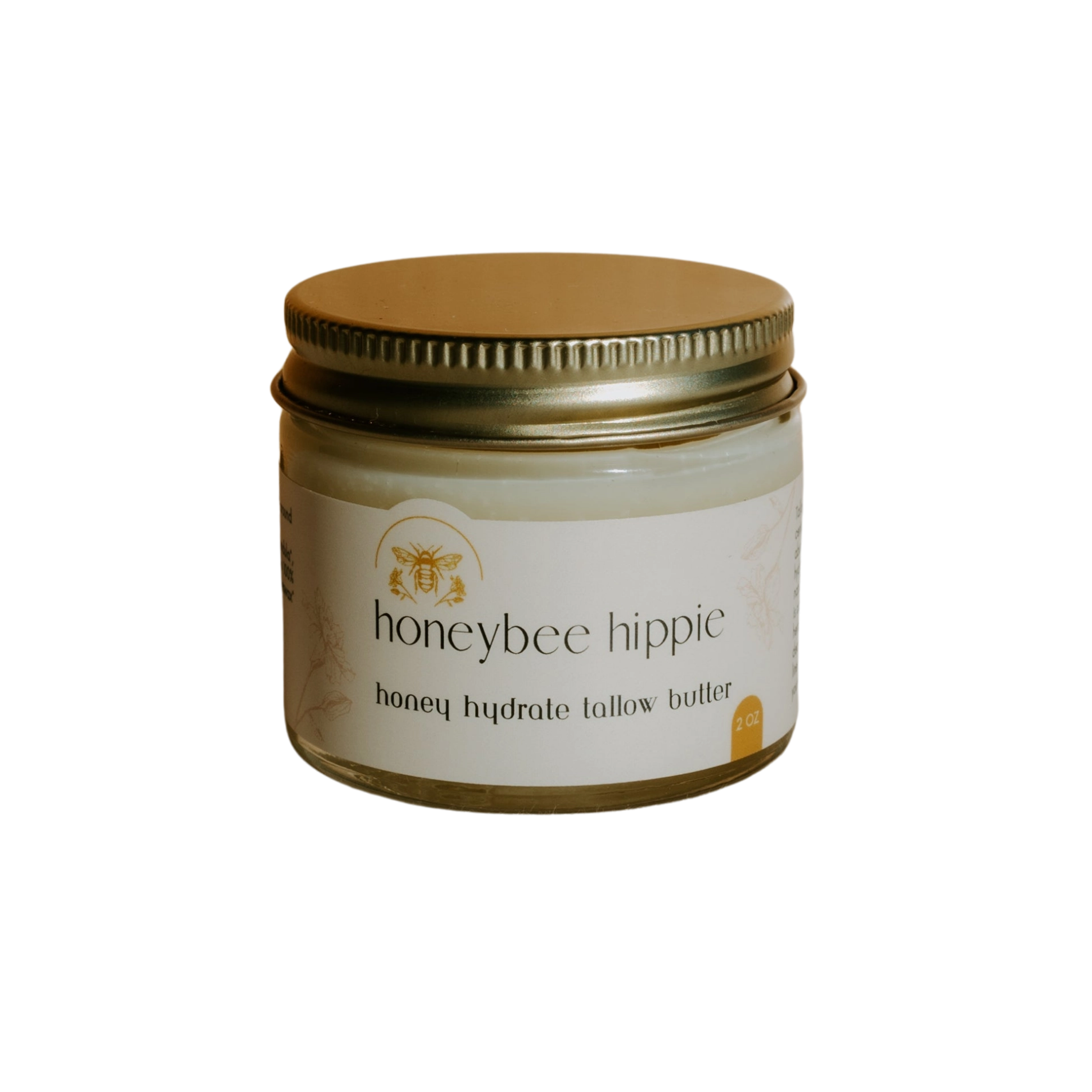 The small jar with a gold lid features "honey hydrate tallow butter" from Honeybee Hippie. With a bee illustration on its label, set against black, it exudes organic charm and promises natural nourishment.