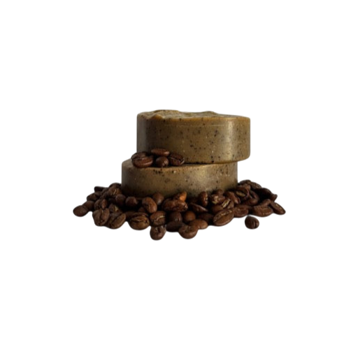 Two Wild Bison Tallow Deep Exfoliating Soap Scrub bars (Shilajit + Decaffeinated Coffee Bean) from Wild Mamas are stacked on whole coffee beans, set against a plain white background—ideal for fans of a rich coffee scrub.