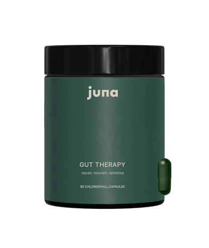 A dark green container of Juna Gut Therapy Supplement with a black lid is shown. The label reads "repair, nourish, optimize" and contains 80 chlorophyll capsules to support gut health. A single green capsule is positioned beside the container.