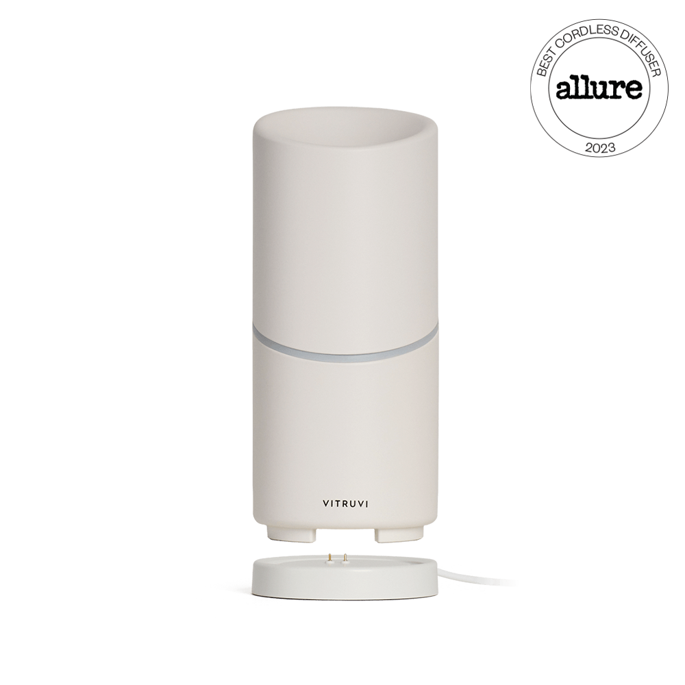 The elegant Move Diffuser by Vitruvi features a smooth, cylindrical design in a light, neutral color. This cordless diffuser doesn't require a plug and has been named the "Best Cordless Diffuser" by Allure in 2023. Its detachable base allows for optimal efficiency in scenting every corner of your space.