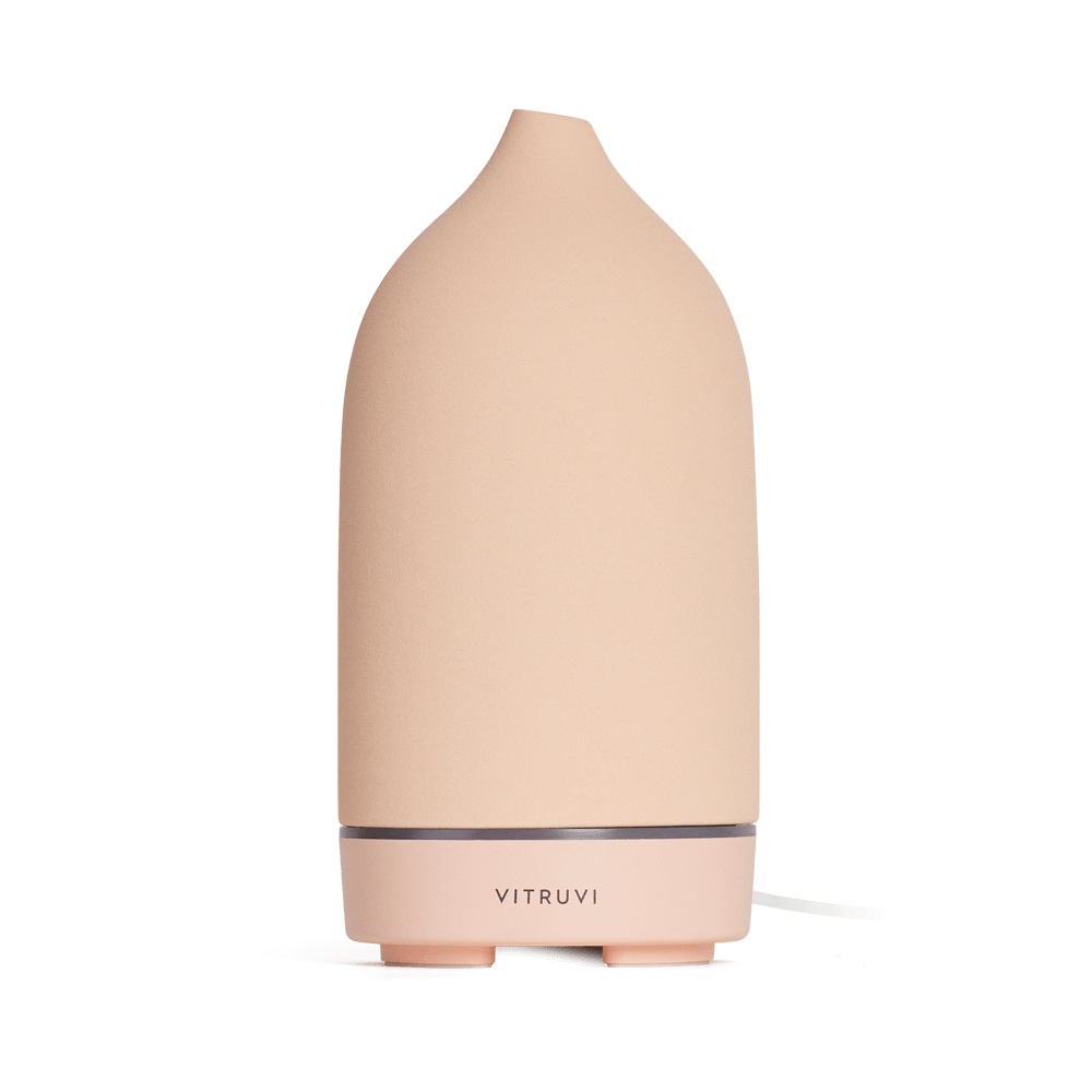 Suede - 
The Vitruvi Stone Diffuser is a beige ceramic diffuser with a smooth, conical shape and a simple, sleek design. It features the "Vitruvi" branding on the front and complements any home decor. It's perfect for diffusing pure essential oils.
