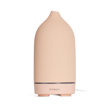 Suede - 
The Vitruvi Stone Diffuser is a beige ceramic diffuser with a smooth, conical shape and a simple, sleek design. It features the "Vitruvi" branding on the front and complements any home decor. It's perfect for diffusing pure essential oils.
