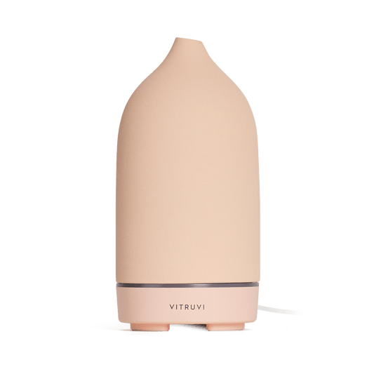 Suede - 
The Vitruvi Stone Diffuser is a beige ceramic diffuser with a smooth, conical shape and a simple, sleek design. It features the "Vitruvi" branding on the front and complements any home decor. It's perfect for diffusing pure essential oils.