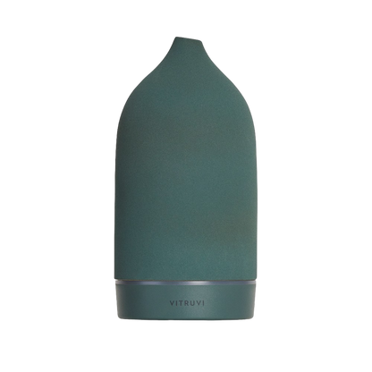 A dark green, conical-shaped Vitruvi Stone Diffuser with a soft matte finish and a tapered top. The word "VITRUVI" is inscribed at the base in subtle lettering. Designed to complement home decor, it uses pure essential oils for a minimalist and elegant touch.