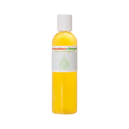 A clear plastic bottle filled with yellow liquid, capped with a white lid. The label reads "Living Libations Seabuckthorn Shampoo" in red and green text with a list of ingredients or details in smaller print below. The label also features a small green tree logo in the center, promising botanical delights within.