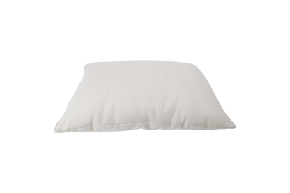 Against a minimalist backdrop rests the All Wool Dream Pillow from Shepherd's Dream, showcasing its plush, soft texture crafted from EcoWool®. The pillow looks plump and inviting, suggesting it is generously filled and ready for use.