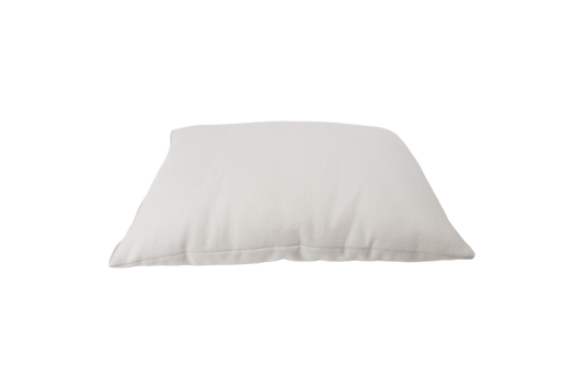 Against a minimalist backdrop rests the All Wool Dream Pillow from Shepherd's Dream, showcasing its plush, soft texture crafted from EcoWool®. The pillow looks plump and inviting, suggesting it is generously filled and ready for use.