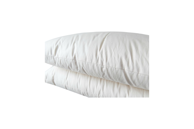 The Ashland Organic Wool Pillows from Shepherd's Dream are stacked on top of each other against a transparent background. These natural sleep pillows, with their fluffy white appearance, look soft and inviting while featuring neatly aligned seams and a smooth texture.