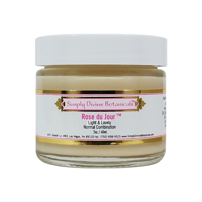 A 2 oz (60 ml) jar of Simply Divine Botanicals Rose du Jour Light Soothing Moisturizer, designed for normal or blemish-prone skin, features a white lid and pink-gold label.