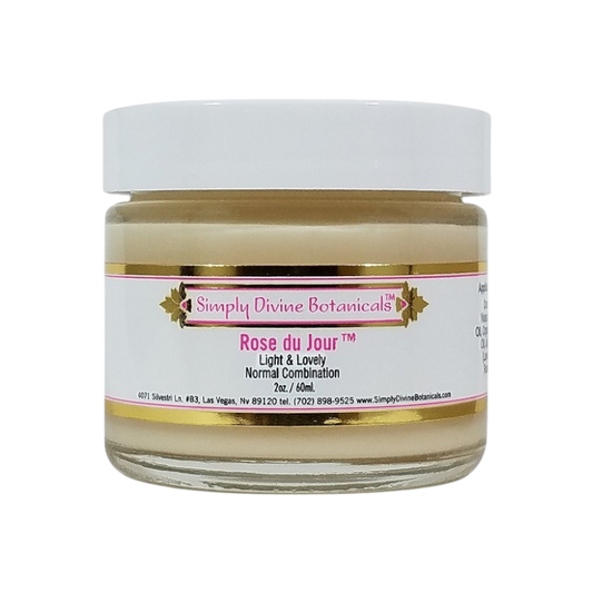 A 2 oz (60 ml) jar of Simply Divine Botanicals Rose du Jour Light Soothing Moisturizer, designed for normal or blemish-prone skin, features a white lid and pink-gold label.