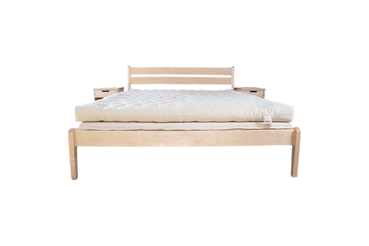 Introducing the minimalist wooden bed featuring the All Wool Mattress by Shepherd's Dream. This bed includes a simple headboard and two small attached side tables, seamlessly blending modern design with understated style and comfort. The product is beautifully showcased against a plain white background.