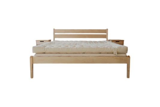 A minimalist wooden Cascade Latex Mattress Base from Shepherd's Dream, featuring a sleek headboard and a substantial light-colored natural latex foam mattress. It has a natural finish with clean lines and modern design, paired with an organic cotton encasement. The setup does not include visible bedding or pillows.