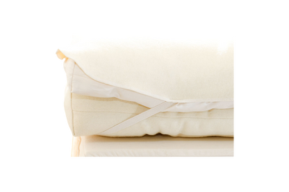 Folded Wool Mattress Protector from Shepherd's Dream, featuring attached elastic straps and dust mite-resistant, breathable wool, displayed against a plain background.