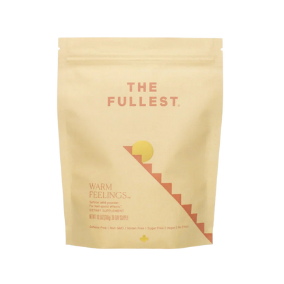 THE FULLEST’s Warm Feelings 30-Day Supply comes in a beige resealable pouch. The minimalist sun and staircase design reflect its mood-supporting, caffeine-free saffron formula—perfect for a calming daily latte ritual.