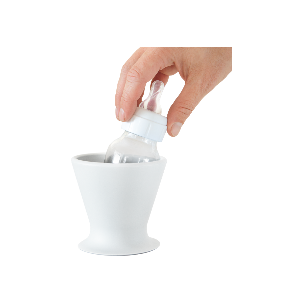 A hand smoothly performs one-handed bottle prep by placing a pink BPA-free silicone baby bottle from bökee into a stylish, white conical bökee Baby Bottle Holder, designed with a wide base. The clear bottle, featuring a white cap and nipple, fits seamlessly inside against a simple white background.