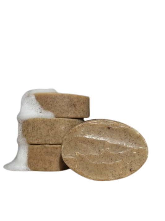 Four oval Wild Mamas Wild Bison Tallow Gentle Exfoliating Soap Scrub bars (Madagascar Vanilla Bean + Manuka Honey) are stacked, the top covered in white foam. One bar in front shows its smooth, textured surface against a plain white background.